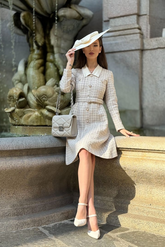a lady in a tweed patchwork dress with a belt